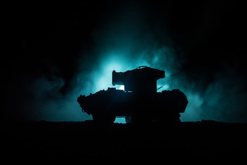 Obraz premium War Concept. Military silhouettes fighting scene on war fog sky background, World War German Tanks Silhouettes Below Cloudy Skyline At night. Attack scene. Armored vehicles. Tanks battle