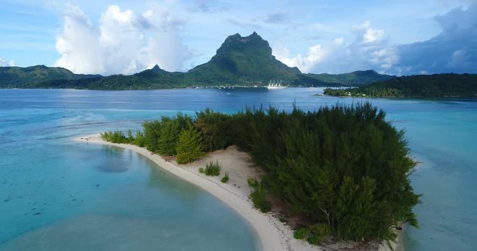 Bora Bora vacation travel paradise small Island with pristine white sand and turquoise sea with cruise ship and mount Otemanu in background. Travel, vacation and summer holiday Aerial drone video.