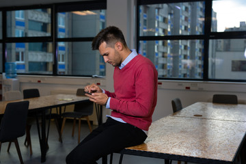 Man typing on the mobile phone in the office