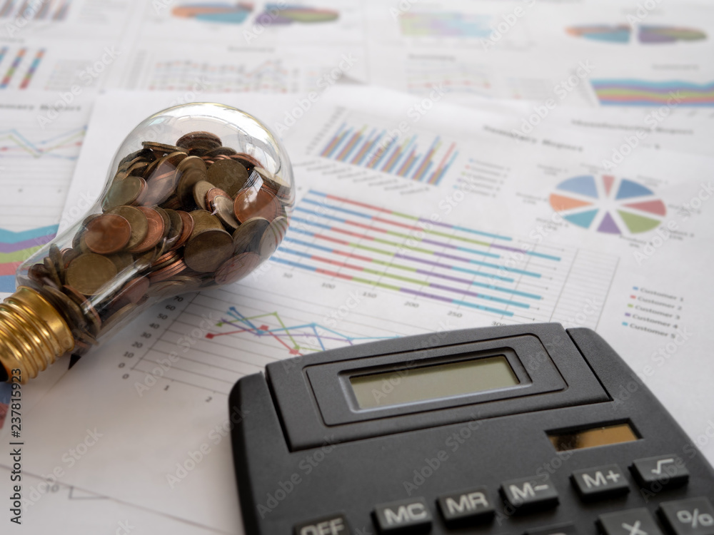Wall mural light bulb with coin and calculator on business graph. concept of cost reduction and reduce energy. 