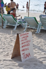 Sign listing available food for sale on beach 