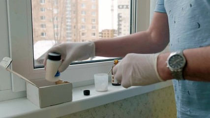 a man in rubber gloves restores a window sill, applies paste to damaged areas with a spatula - Powered by Adobe