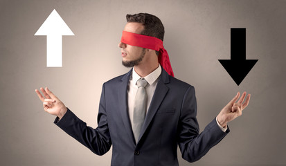 Covered eye businessman choosing between two directions 