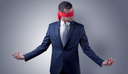 Covered eye, indecisive businessman standing blind in front of a wall