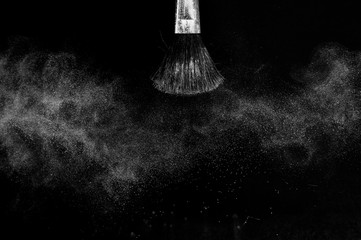 white powder splash and brush for makeup artist or beauty blogger in black background