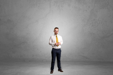 Alone handsome businessman standing in a dark empty room