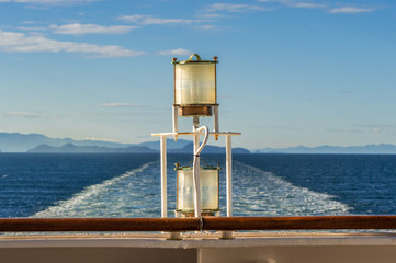 Sunlit glass and metal sternlight of ship. Stephen's Passage, Alaska, USA.