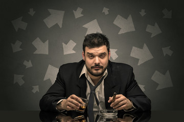 Drunk disappointed man sitting at table with arrows around
