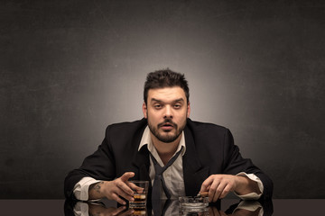 Young drunk man at his office with free dark copyspace