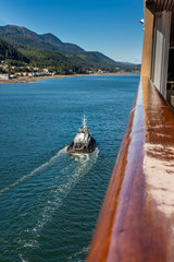 Tugboat guiding cruise ship in to port, Gastineau Channel, Juneau, Alaska, USA.