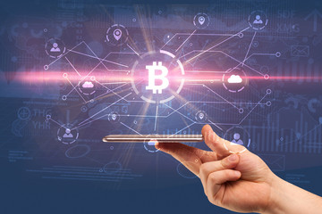 Hand using phone with cryptocurrency bitcoin link network and online concept
