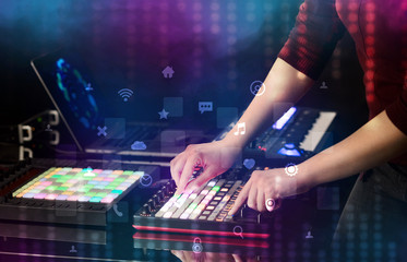 Hand mixing music on dj controller with social media concept icons
