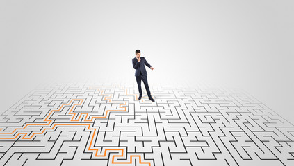 Young entrepreneur standing in a middle of a labyrinth with the solution
