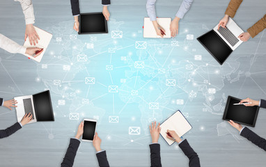 Group of people with devices in hands working in team on tablets, laptops with application concept
