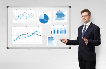 Handsome businessman presenting report on white board with laser pointer 
