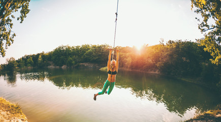 A woman is riding a swing.