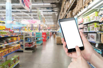 Female hand holding mobile smart phone on Supermarket blur background, business concept