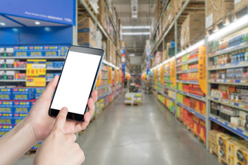 Female hand holding mobile smart phone on Supermarket blur background, business concept
