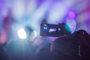 Use advanced mobile recording, fun concerts and beautiful lighting, Candid image of crowd at rock...