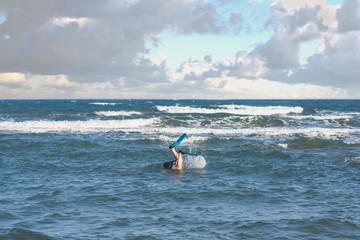 legs of fat man in the swimming flippers on the sand on the beach