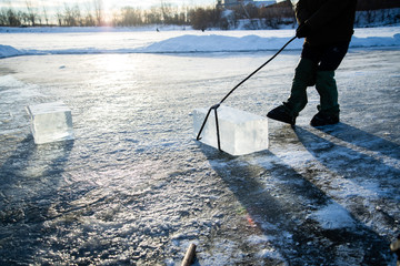 workers mine large cubes of natural river ice