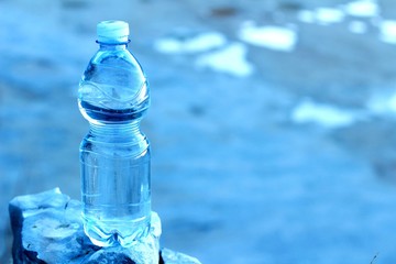 Agua mineral en botella, sobre una roca