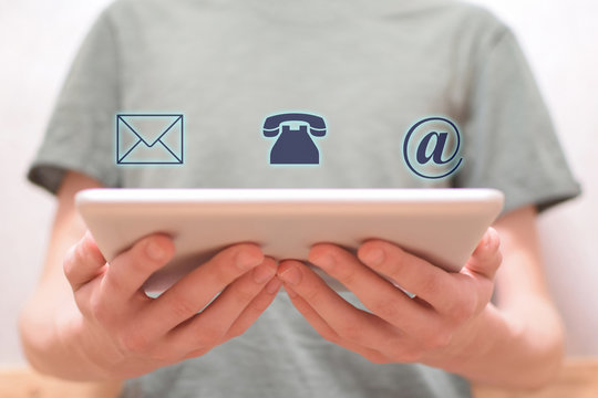 Man hands holding white tablet with email envelope, telephone and e-mail address virtual  icons. Business connection contact us and call center customer support service concept.