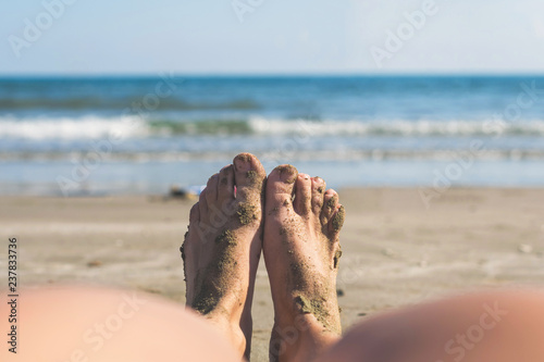 Female Legs And Feet In The Wet Sand On The Beach On The Sea