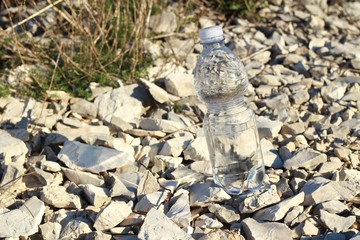 Agua mineral en botella, sobre una roca