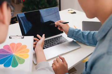Photo editors looking at camera in studio sitting on the desk
