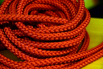 shimmering orange nylon rope background, coiled orange industrial rope made of nylon or synthetic