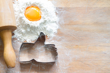 I like baking food concept with thumbs up cookie cutter on wooden background
