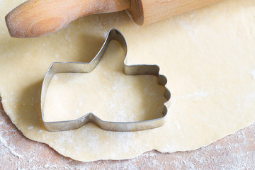 I like baking food concept with thumbs up cookie cutter on wooden background
