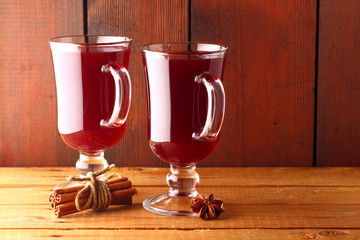 Mulled wine on wooden boards. Christmas mulled wine in glass cups. Alcoholic drink of wine and fruit and honey. Festive drink on wooden boards
