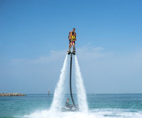 Father and his daughter posing at new flyboard at tropical beach. Positive human emotions, feelings, joy. Funny cute child making vacations and enjoying summer. - obrazy, fototapety, plakaty