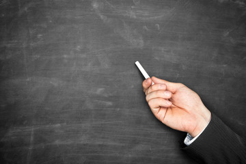 Businessman hand holding chalk and pointing on blackboard