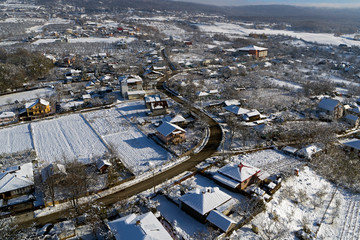drone aerial view with houses and road in winter season