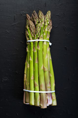 Raw asparagus on dark surface. View from above