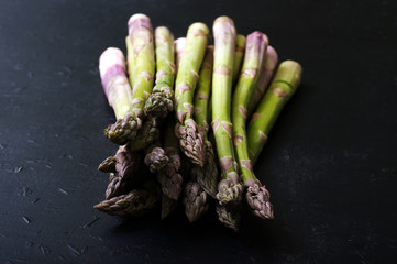 Raw asparagus on dark surface. Macro shooting. Shallow depth of field, blurred background