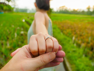 close up couple hands man holding happy fiance hand with diamond engagement ring on her finger...