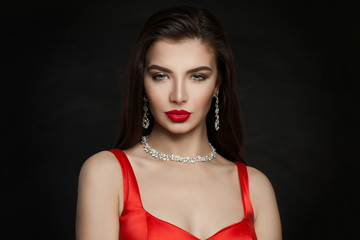Gorgeous woman brunette with red lips makeup, diamond necklace and dark brown hair