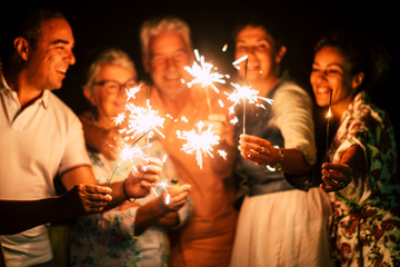 group of people have fun celebrating together new year eve or birthday with sparkles light and...