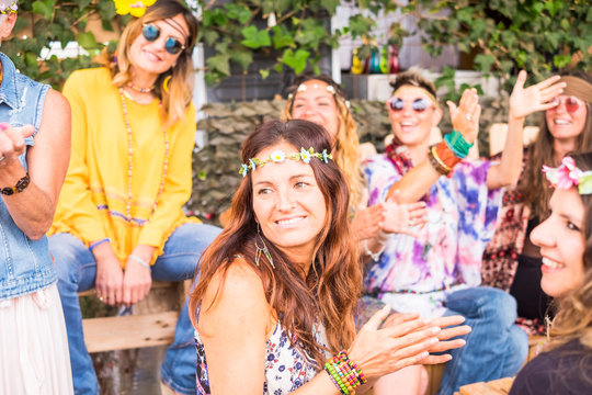 Group of women friends different ages and generations have fun together in hippy coloured style during a party celebration with a lot of smile and laugh - happiness and friendship for girls concept