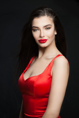 Fototapeta premium Young perfect brunette woman with red lips makeup and dark hair on black background