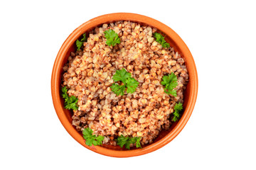 Cooked buckwheat in a rustic earthenware bowl, garnished with fresh parsley, shot from the top, isolated on a white background with a clipping path