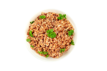 Cooked buckwheat in a bowl, garnished with fresh parsley, shot from the top on a white background, isolated with a clipping path