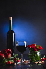Red wine in a glass. Romantic evening with a glass of wine to Valentine's day.Holiday composition on a black table  and  background.