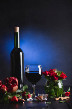 Red wine in a glass. Romantic evening with a glass of wine to Valentine's day.Holiday composition on a black table  and  background.