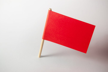 Miniature blank red flag. Ready for a Message. Paper flag Isolated on white background.