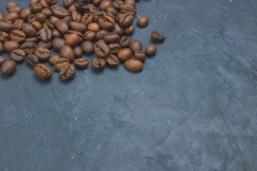 roasted coffee beans scattering in the corner of the background. beans on a dark background. view from above. copy space.